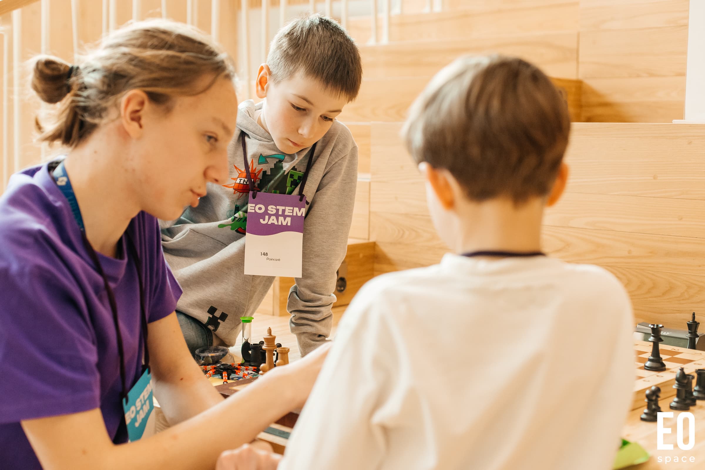 A volunteer helping children with a puzzle at EO STEM Jam