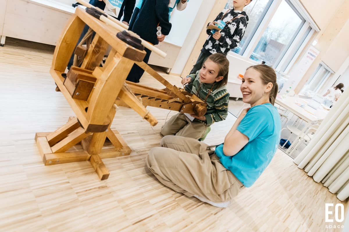 Children playing with a wooden trebuchet