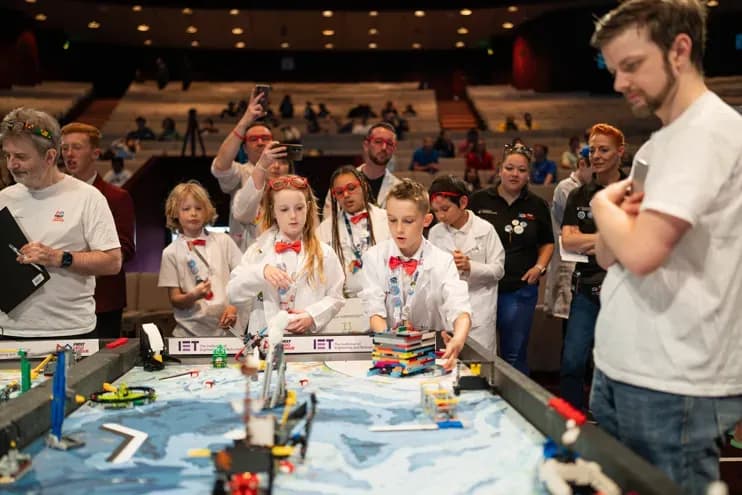 Kids building and programming LEGO robots at a FIRST LEGO League event